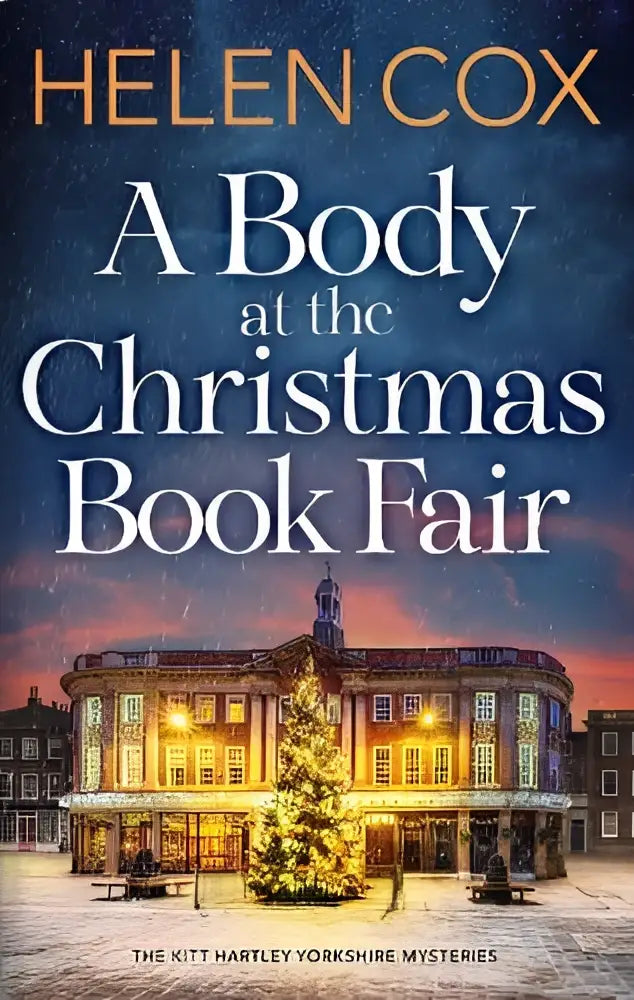 The book cover of a body at the christmas book fair by helen cox showing a snowy scene with an illuminated building and decorated tree