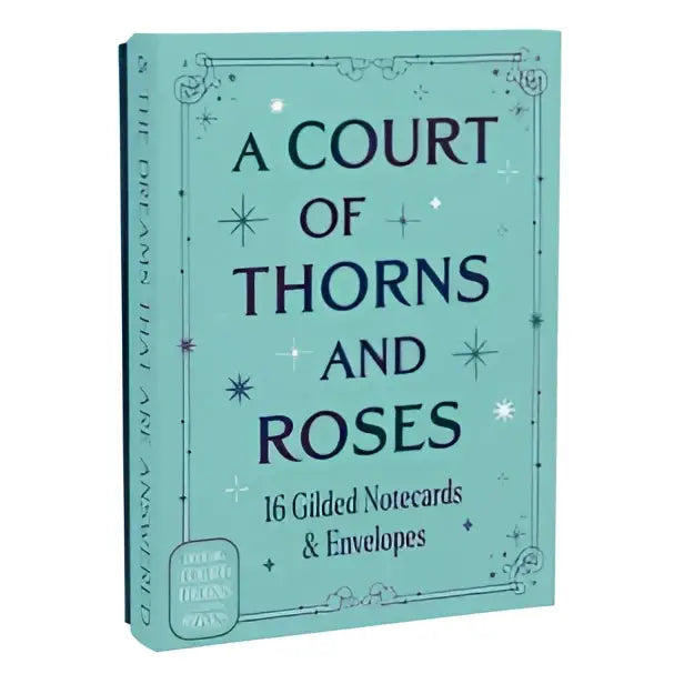 A mint green hardcover notebook with star motifs titled a court of thorns and roses from the official gilded notecards collection