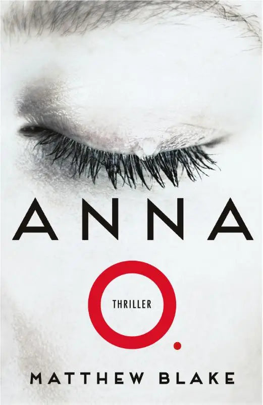 De boekcover van anna o toont een close-up van een oog met lange wimpers en een grijsachtige huid, over iemand die al vier jaar niet wakker geworden is en van moord wordt verdacht