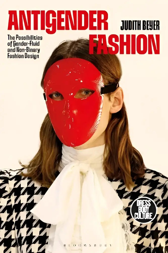 Een vrouw draagt een glanzend rood masker met zwarte banden en een zwart-witte ruitjas in antigender fashion design