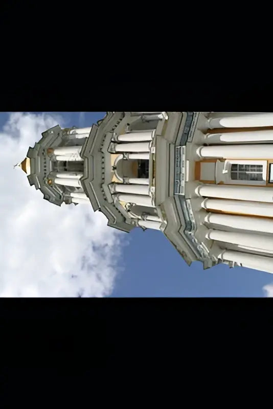 Witte stenen toren met klassieke zuilen van corte penal internacional onder blauwe hemel bij corte penal internacional y los acuerdos de paz