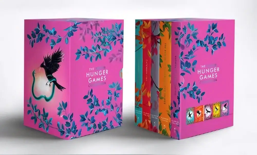 Deluxe hunger games box set met vijf zachte kaft boeken roze hardcover met blauw bloemenpatroon en zwarte vogelillustratie