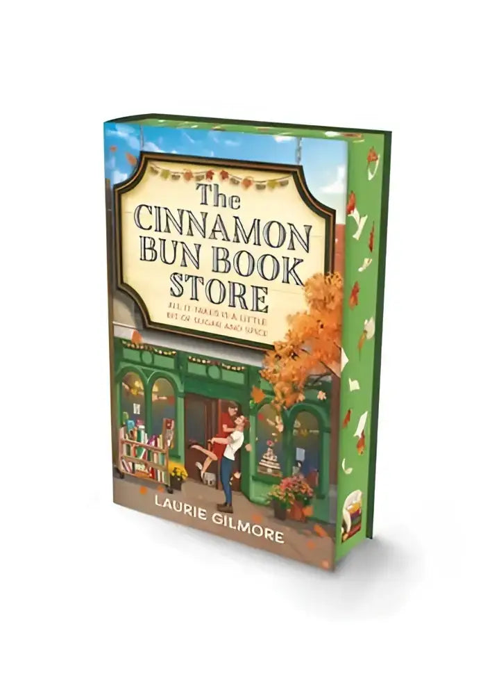De cinnamon bun boek in de dream harbor deluxe editie heeft een groene hardcover met een herfstige illustratie