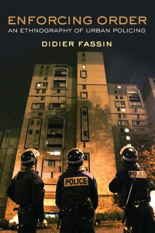 Boekcover van enforcing order een etnografie van urban policing met politieagenten bij nacht voor verlicht appartementencomplex