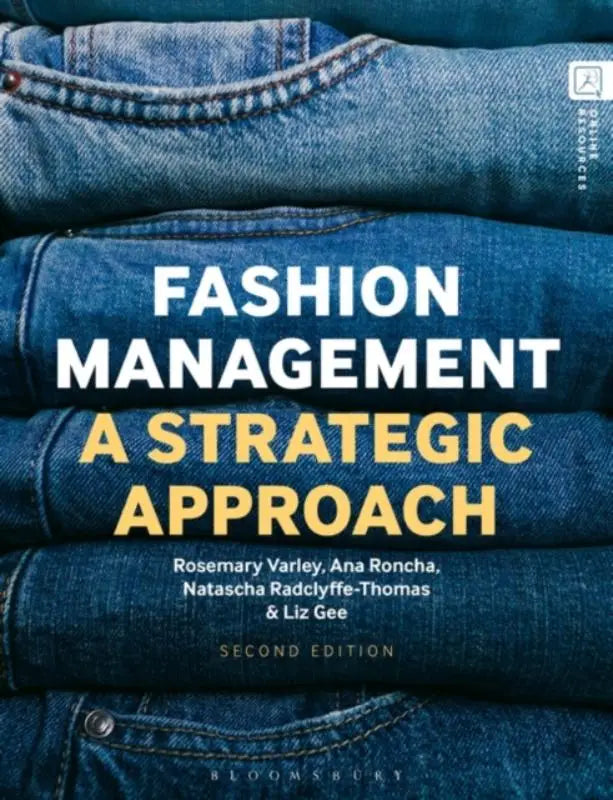 De 2nd edition van fashion management boek met titel in witte en gele letters op blauwe denim stapel achtergrond