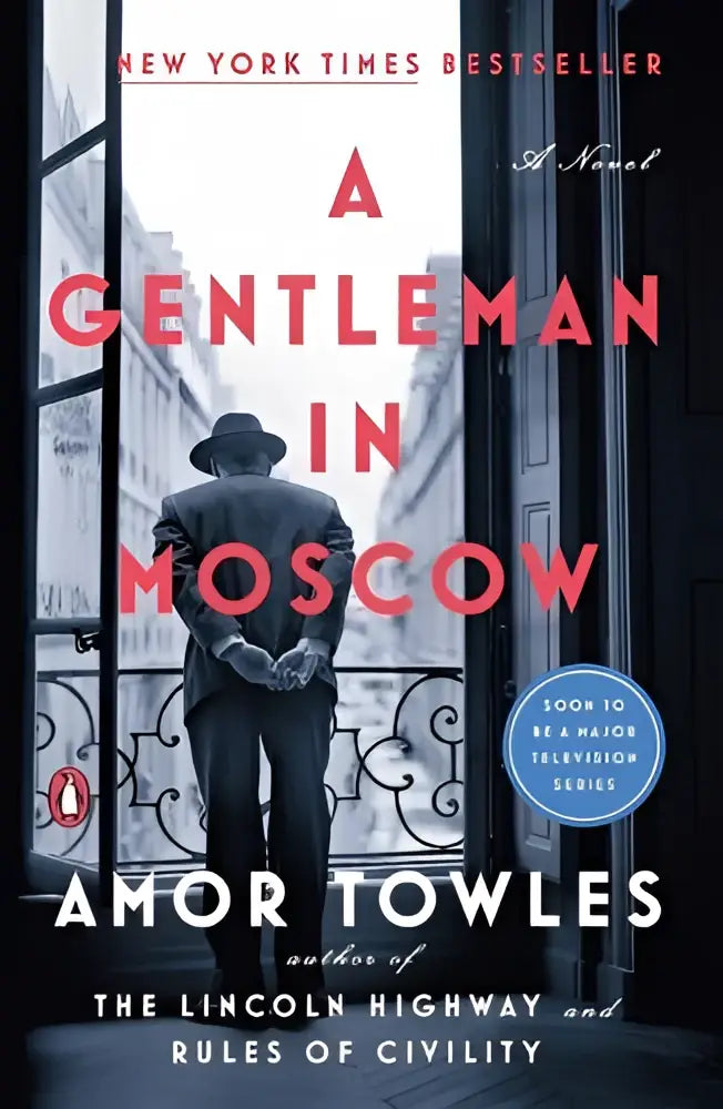 Een zwart-wit omslag van de roman gentleman in moscow met een man in donker pak en hoed bij een sierlijke deur