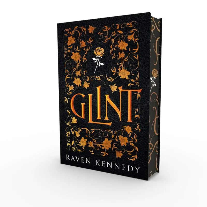 Zwarte hardcover boek glint met gouden bloemmotief en witte roos, perfect voor raven kennedy en gouden gevangene fans