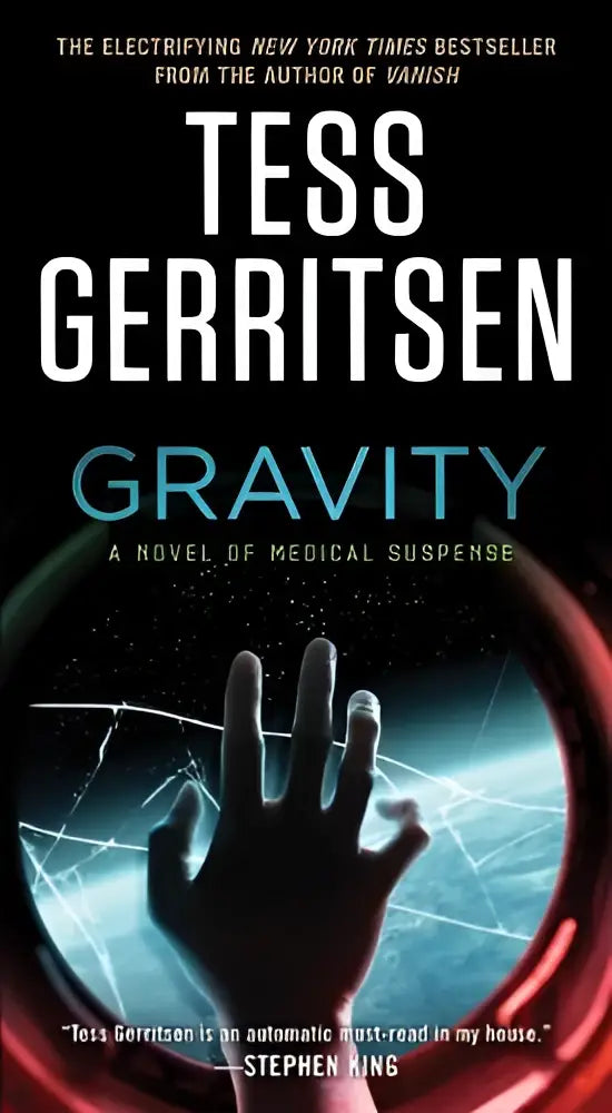 De boekcover van gravity door tess gerritsen toont een zwart-witte hand door gebarsten glas tegen een kosmische achtergrond in spannende fictie