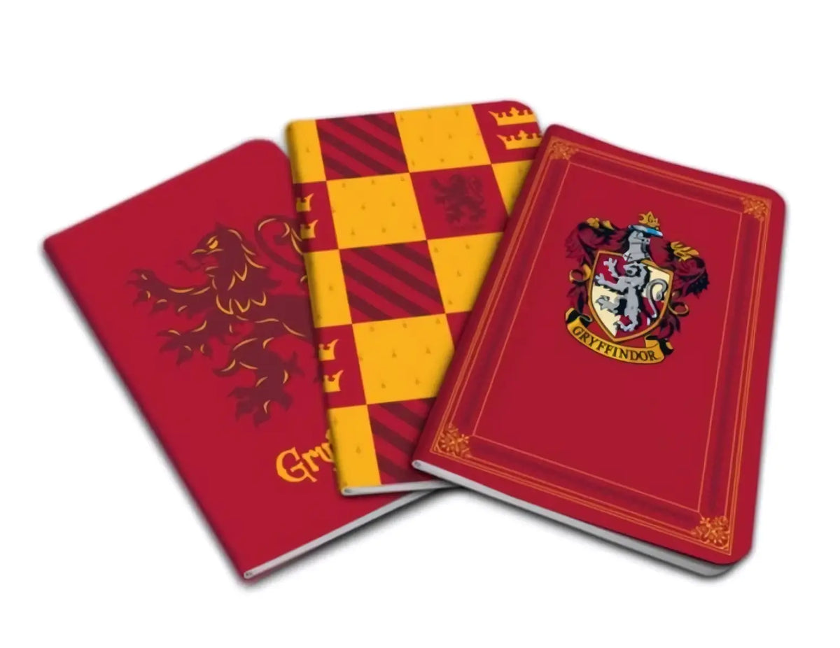 Set van drie harry potter pocket notebooks met gryffindor, hufflepuff en slytherin huisontwerpen in rood en goud