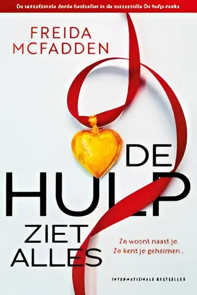 Een gouden hartvormige hanger aan een rode lint voor het boek hulp ziet alles van freida mcfadden psychologische thriller