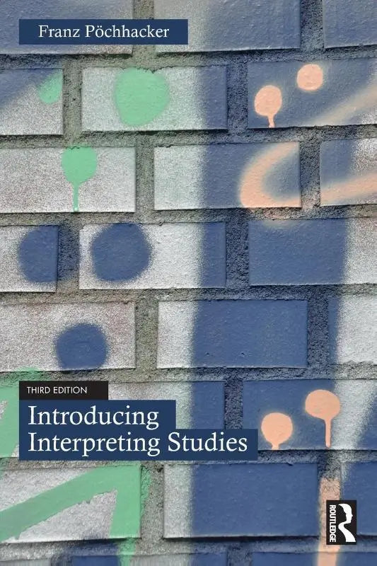 De boekcover van introducing interpreting studies door franz pöchhacker met een bakstenen achtergrond en groene en perzikkleurige verfspatten