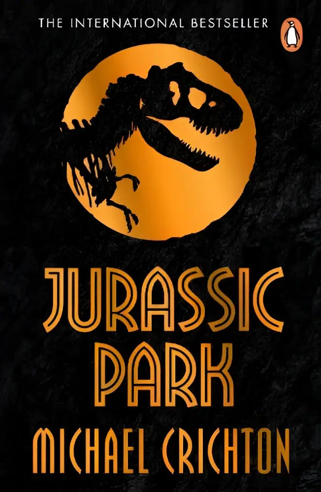 De jurassic park boekcover toont een zwarte t-rex silhouet tegen een oranje achtergrond met gouden letters