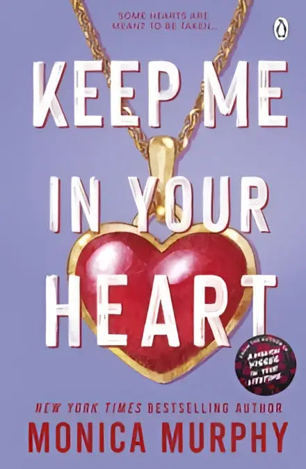 Een glanzend rood hartvormig hangertje met gouden ketting uit keep me in your heart van monica murphy