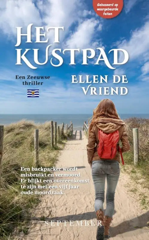 Een levendig rode rugzak van het kustpad gedragen door een persoon lopend op een zandpad richting de oceaan