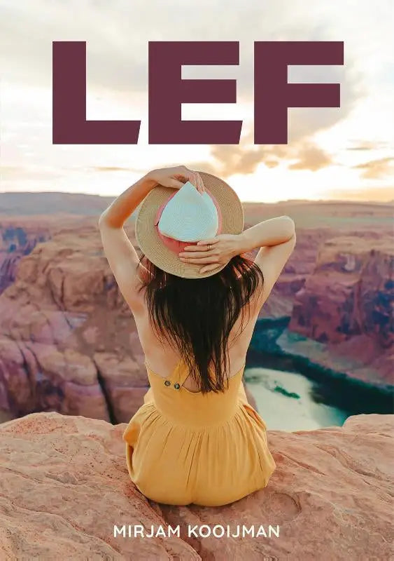 A woman in a yellow dress and straw hat sits on a rocky ledge in the book lef by mirjam kooijman scholten uitgeverij