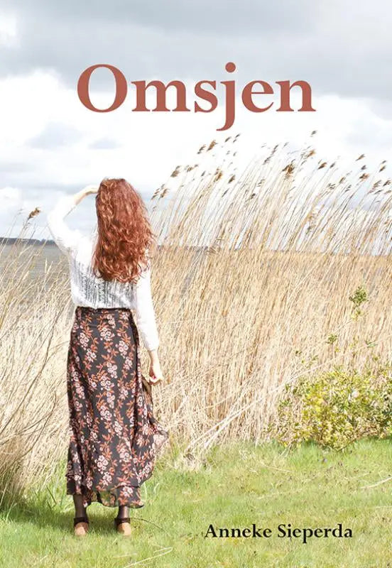 Vrouw met lang rood haar in een witte kanten top en een donkebabruine bloemenrok in een veld anneke sieperda omsjen