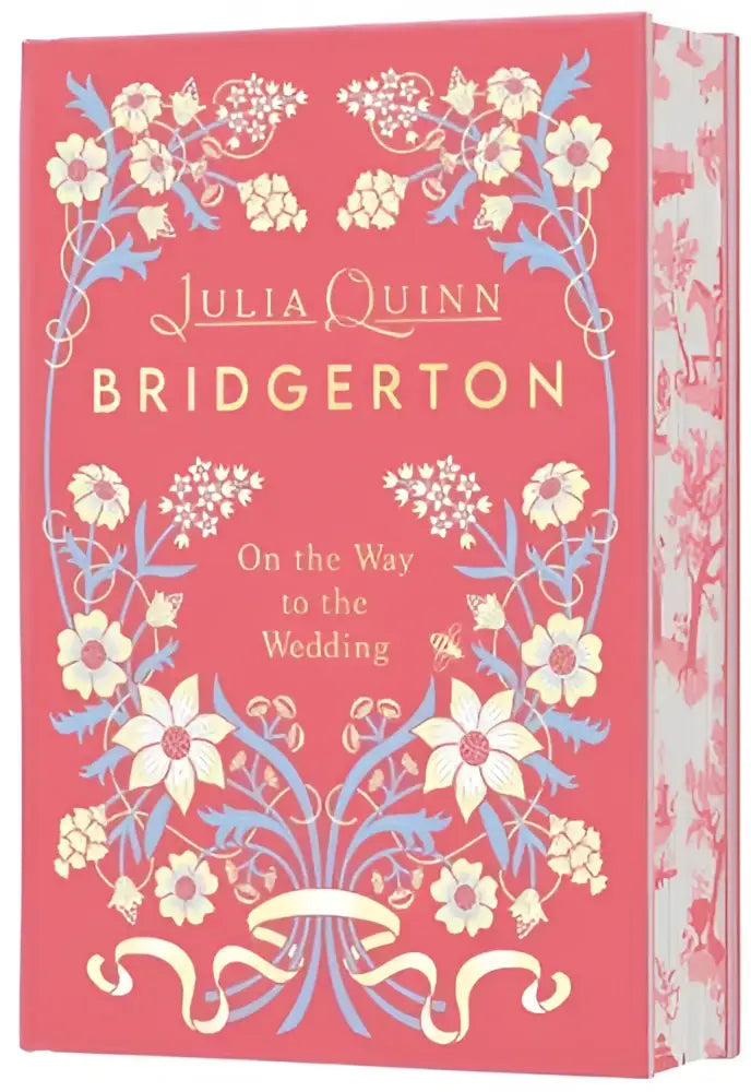 Een roze hardcover boek met een bloemmotief getiteld Bridgerton on the way to the wedding deluxe edition door Julia Quinn