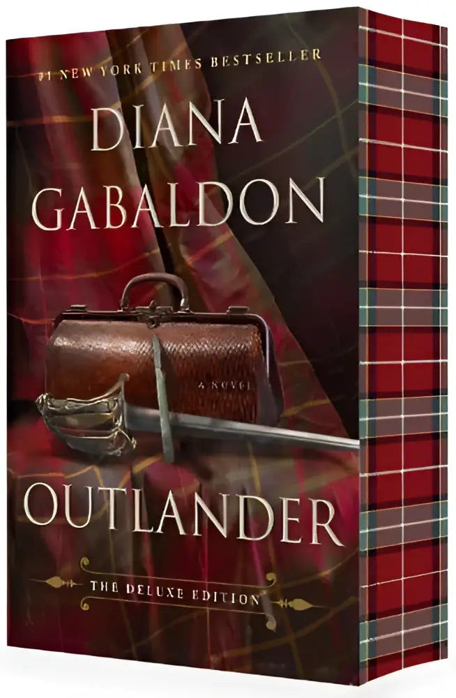Deluxe edition outlander boek met rode en zwarte geruite hardcover en zilveren zwaardillustratie op omslag