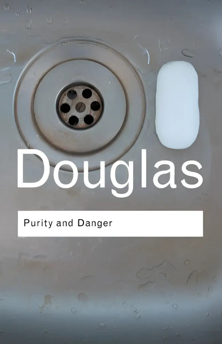 Een witte, rechthoekige stukzeep naast een metalen gootsteenafvoer in het product purity and danger
