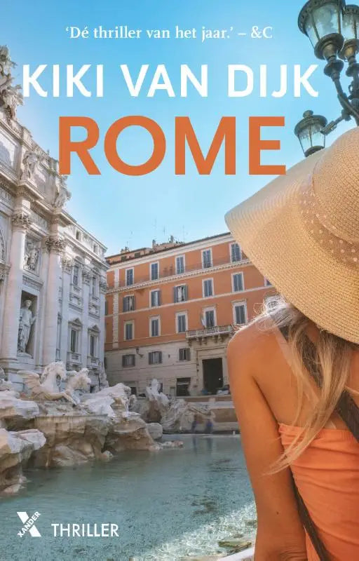 Een vrouw met een breedgerande strohoed met witte stippen en een oranje mouwloze jurk bij de Trevifontein in Rome