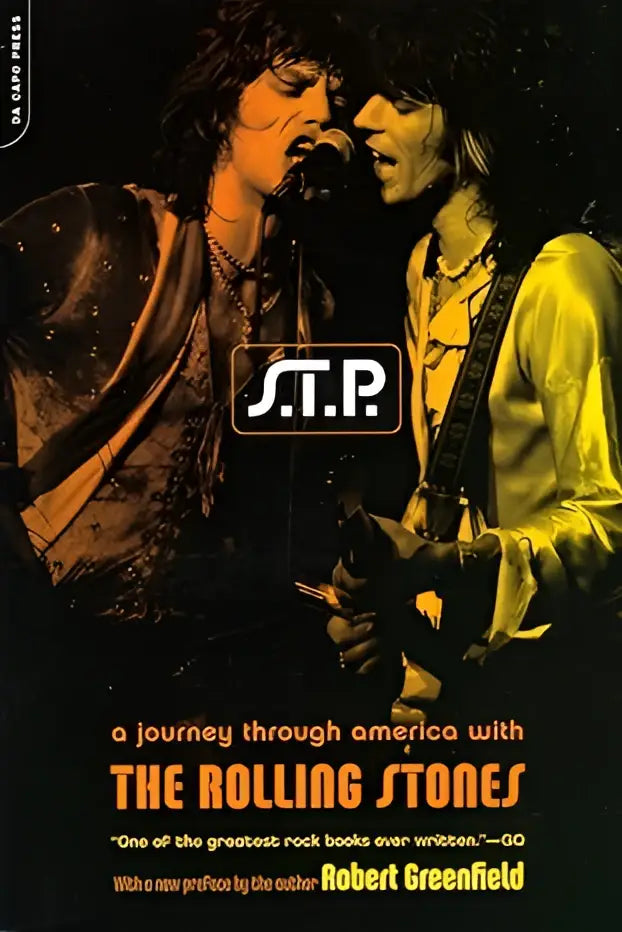 Het boek s.t.p. toont de rolling stones in een zwartwitfoto met gele en oranje verlichting op een donkere achtergrond