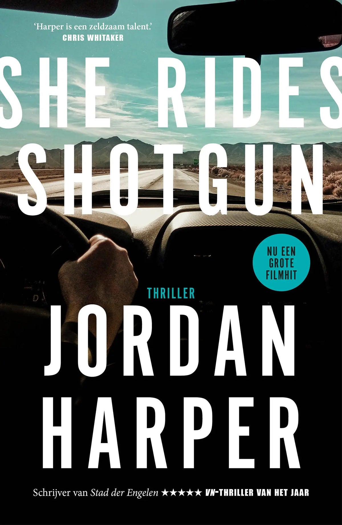 The book cover of she rides shotgun by jordan harper showing bold white text over a car interior with desert view