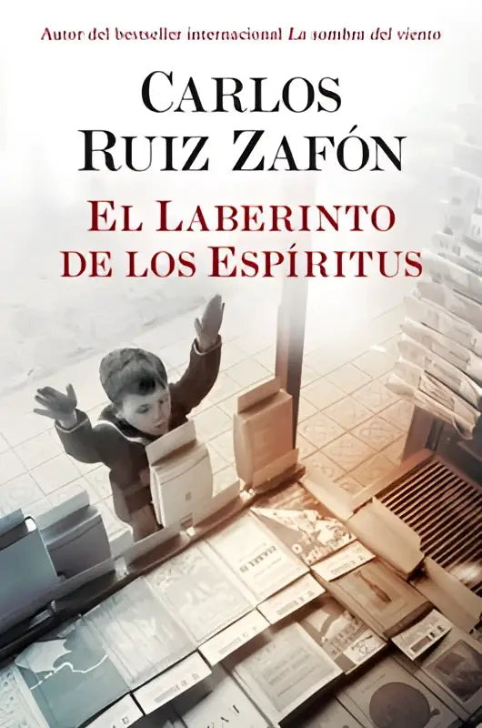 De boekcover toont een jongen in een donkere jas tussen verspreide boeken en papiertjes met de titel el laberinto de los espiritus van carlos ruiz zafón uit los libros olvidados