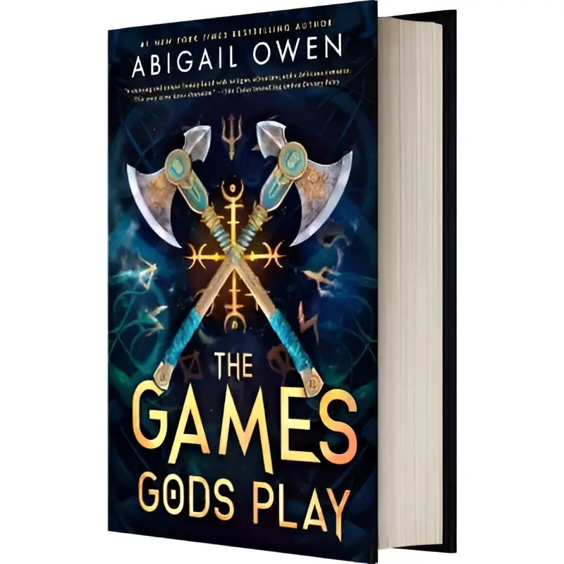 The games gods play door Abigail Owen hardcover boek met illustratie van twee gekruiste bijlen op donkere achtergrond