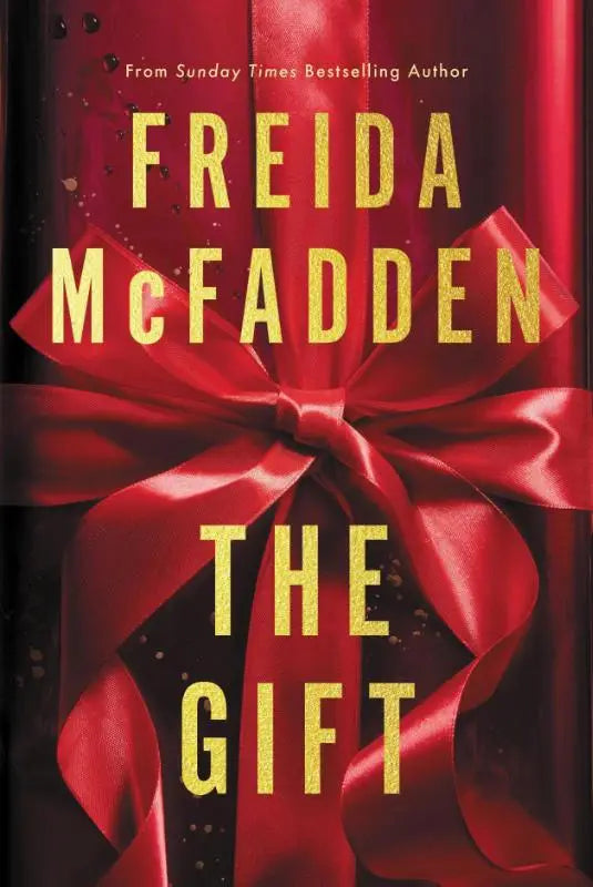 Rood satijnen lint in een strik op de omslag van het boek the gift van freida mcfadden psychologische thriller
