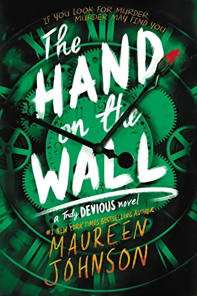 The hand on the wall paperback by maureen johnson features bold white lettering on a dark green gear background with stevie bell