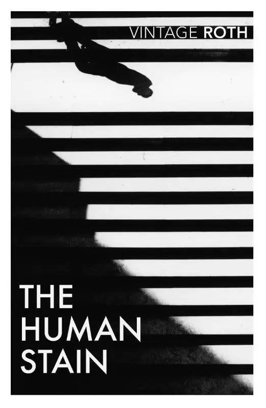 Zwart-witte boekcover van the human stain door vintage roth met een silhouet van een persoon die zebrapaden kruist