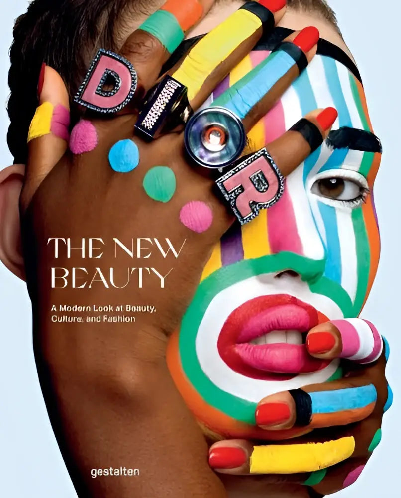 Hand met kleurrijke make-up en nagellak bedekt deels gezicht met regenboogstrepen in The New Beauty boekcover