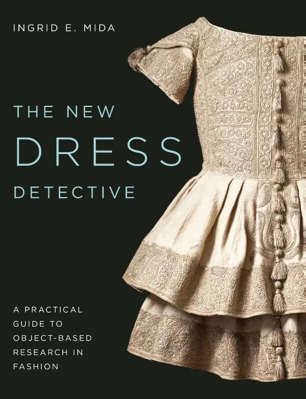 De nieuwe dress detective praktische guide toont de achterkant van een crème historische jurk met borduurwerk en kwastjes