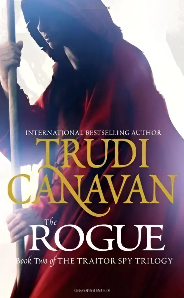 Het boek the rogue tweede deel van de traitor spy trilogie toont een figuur in een rood gewaad met staf