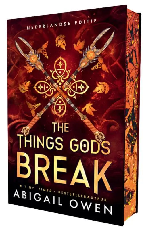 The things gods break hardcover book with an ornate red and gold cover featuring crossed spears and intricate designs