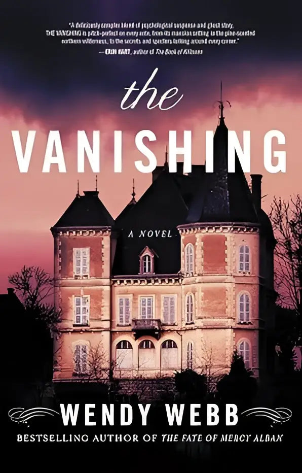 The vanishing novel by wendy webb shows an ornate pinkish brown stone chateau with dark slate roofs at twilight