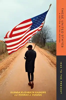Een persoon gekleed in donkere kleding loopt over een onverharde weg met een Amerikaanse vlag bij These united states