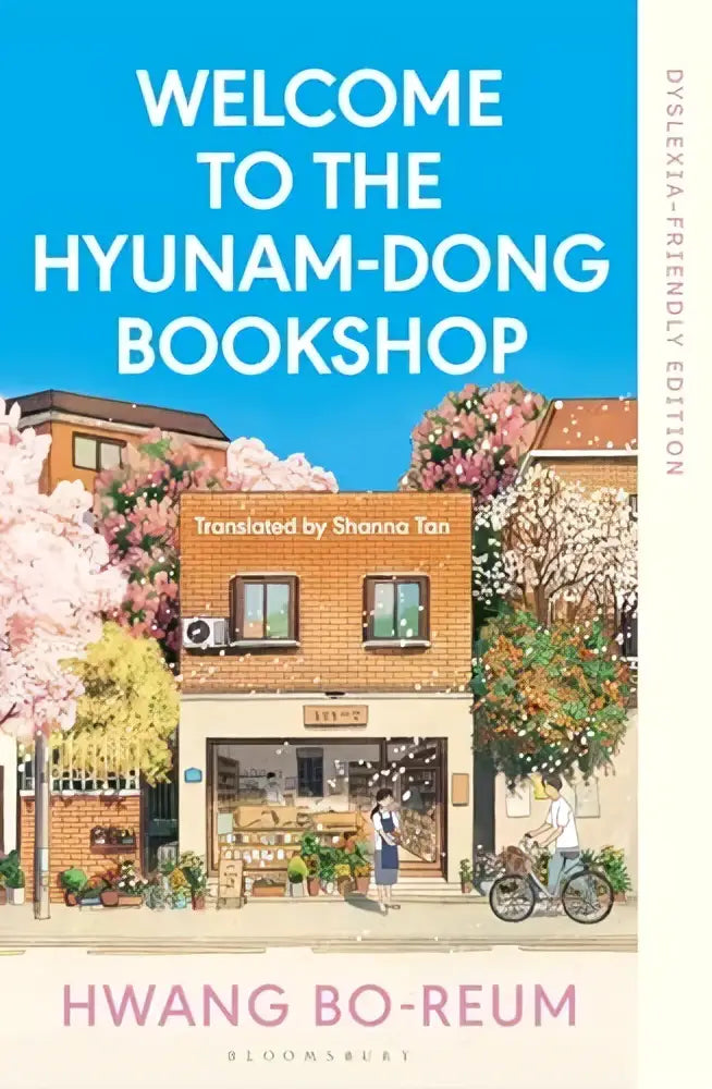 De cover van het boek welcome to the hyunam-dong bookshop dyslexia-friendly edition toont een winkelgevel met roze bloesems
