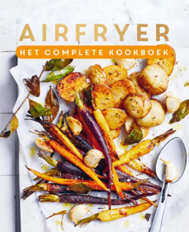 De cover van airfryer het complete kookboek toont geroosterde gele en paarse wortelen en krokante aardappelen op bakpapier
