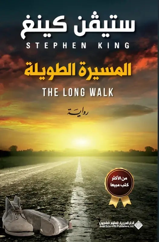 Het boek de long walk van stephen king met arabische titel en grijze versleten sneakers op een zonovergoten weg