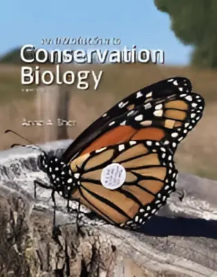 De boekcover toont een monarchvlinder op droog gras bij de titel an introduction to conservation biology van anne e