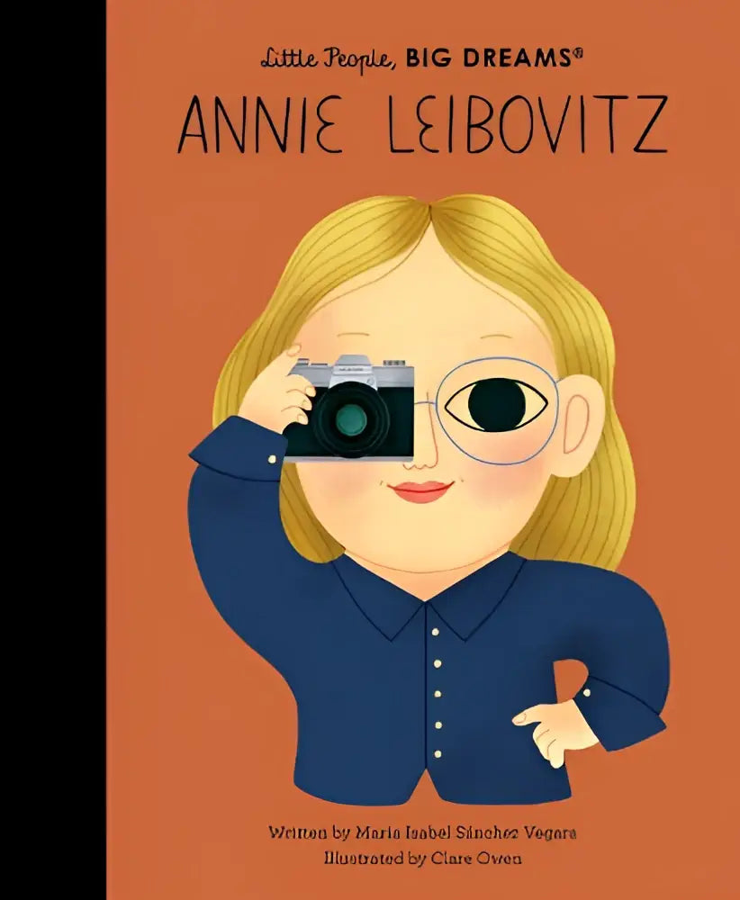 Een gestileerde illustratie van een zilveren camera met zwarte lens vastgehouden door een cartoonpersonage in Annie Leibovitz little people big dreams