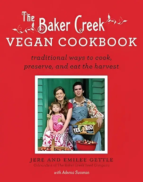 De baker creek vegan cookbook is een felrode hardcover kookboek met witte tekst en een afbeelding van drie mensen met groenten op de voorkant