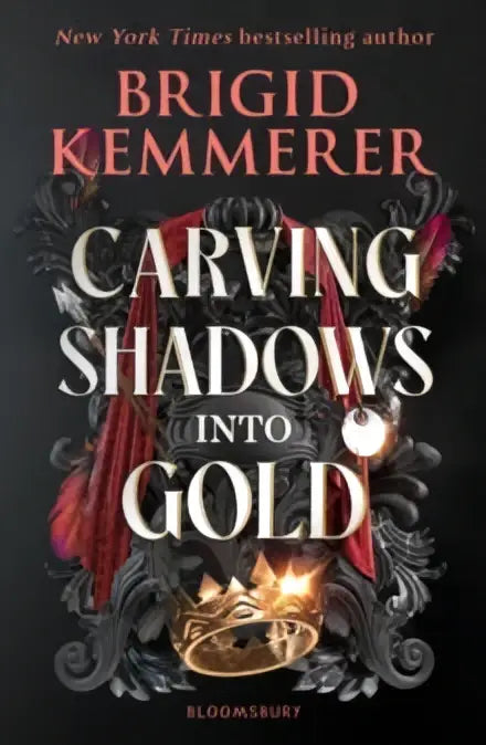 The book cover of carving shadows into gold by brigid kemmerer features a golden crown framed by ornate black and red elements