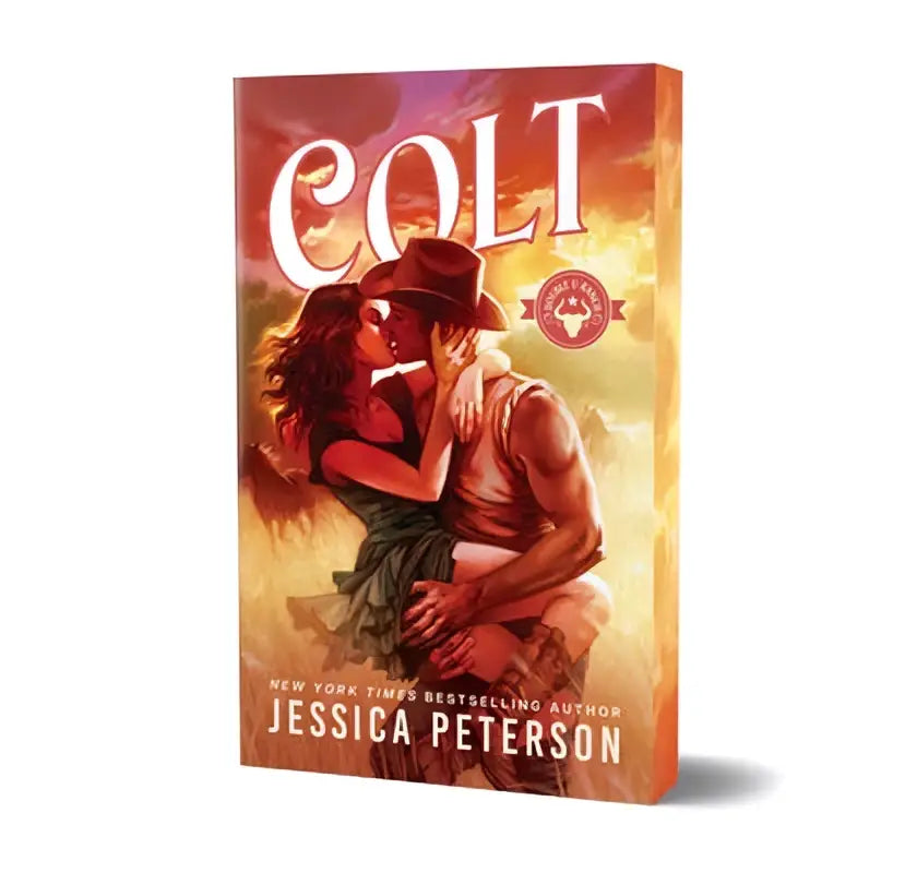 De deluxe edition van colt door jessica peterson toont een warme oranje en rode cover met een omhelzing onder dramatische lucht hedendaagse romantiek