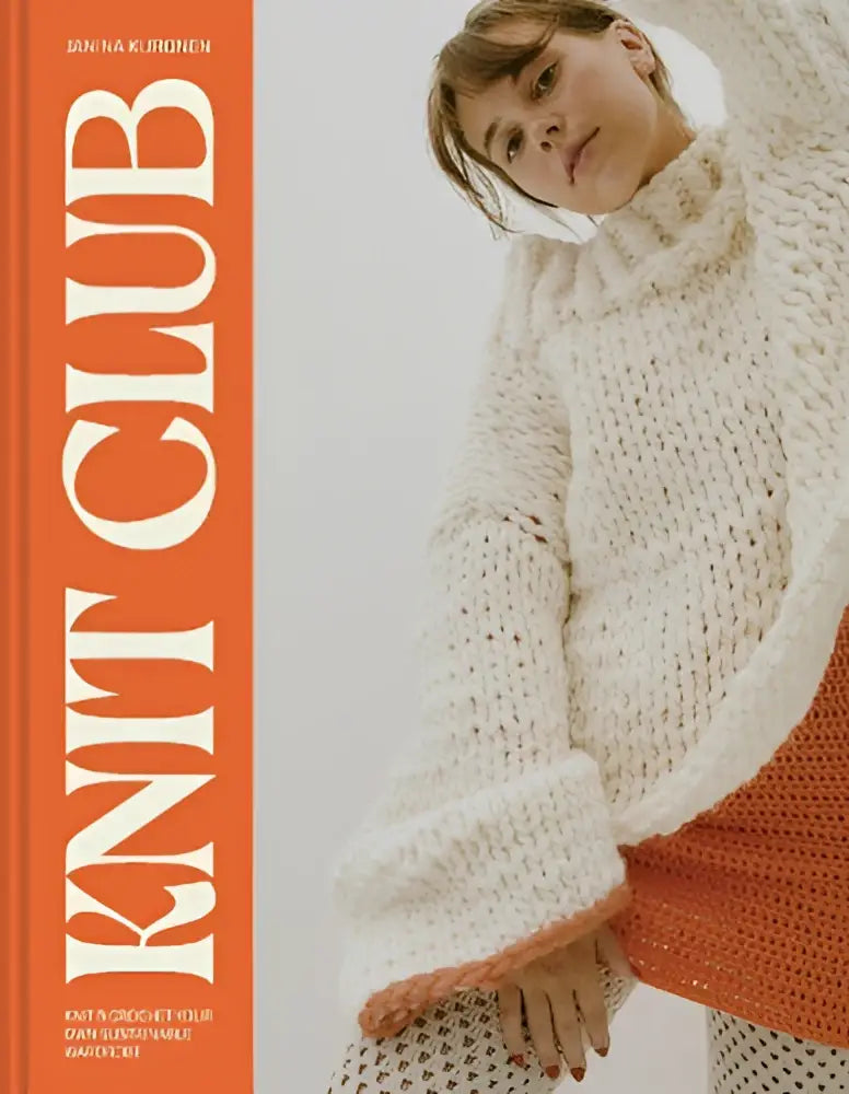 A woman wearing a cream-colored chunky knit turtleneck sweater with orange-trimmed hem for your own sustainable wardrobe