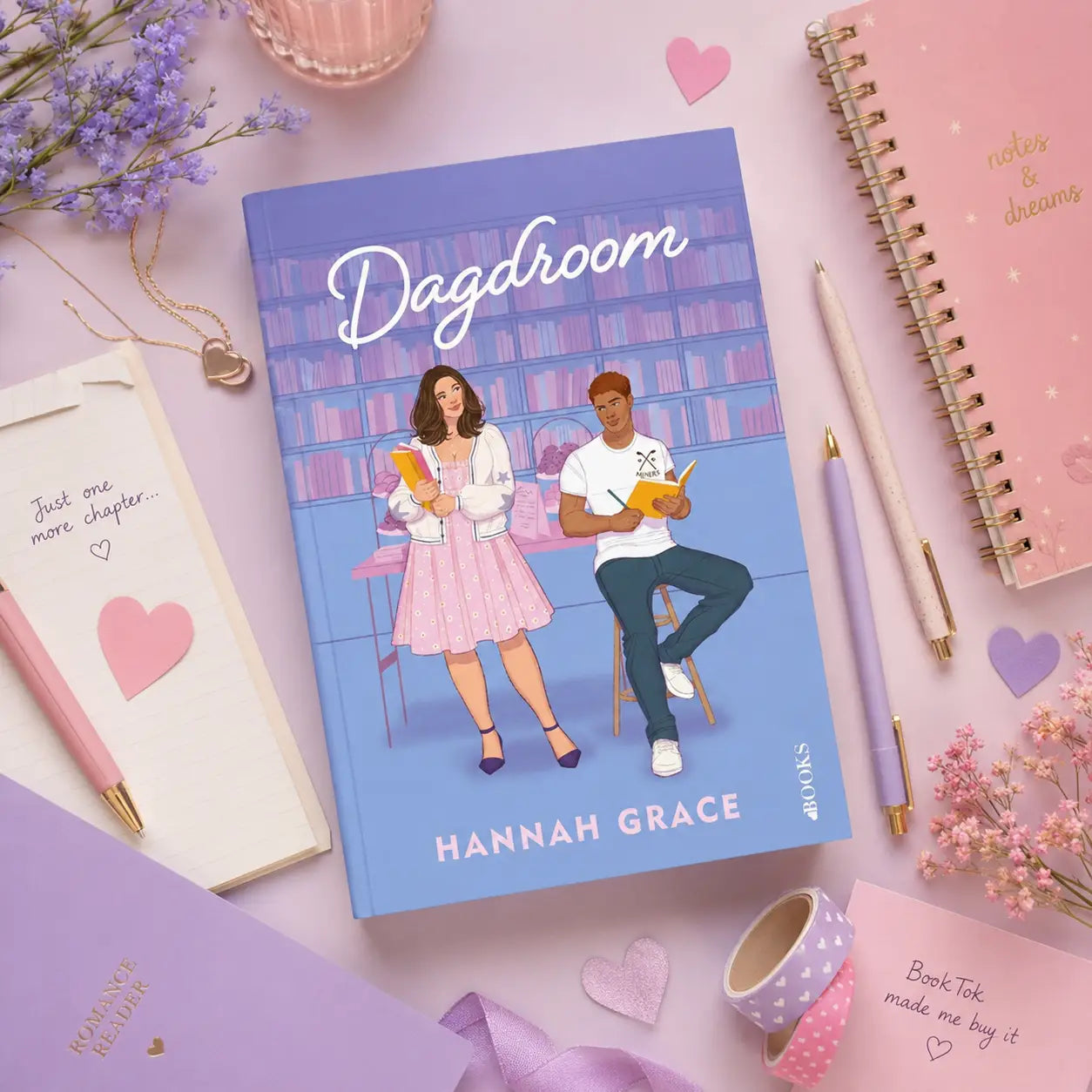 Blauw hardbackboek dagdroom van hannah grace met illustratie van vrouw in roze jurk en man in casual kleding aan tafel maple hills-serie