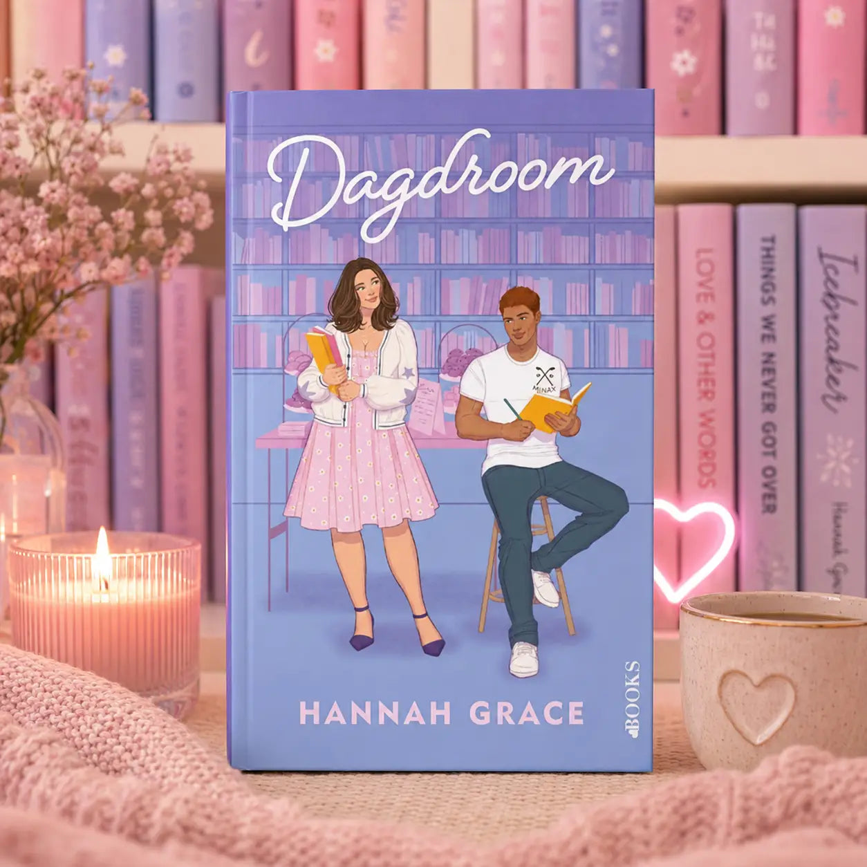 Een zachte lavendelkleurige hardcover boek dagdroom van hannah grace met een illustratie van een vrouw en man aan een bureau in de maple hills-serie