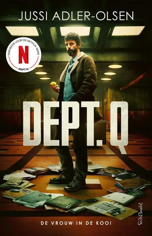 The book cover of Dept Q - De vrouw in de kooi shows a man in a dark brown coat over a teal shirt standing among scattered documents