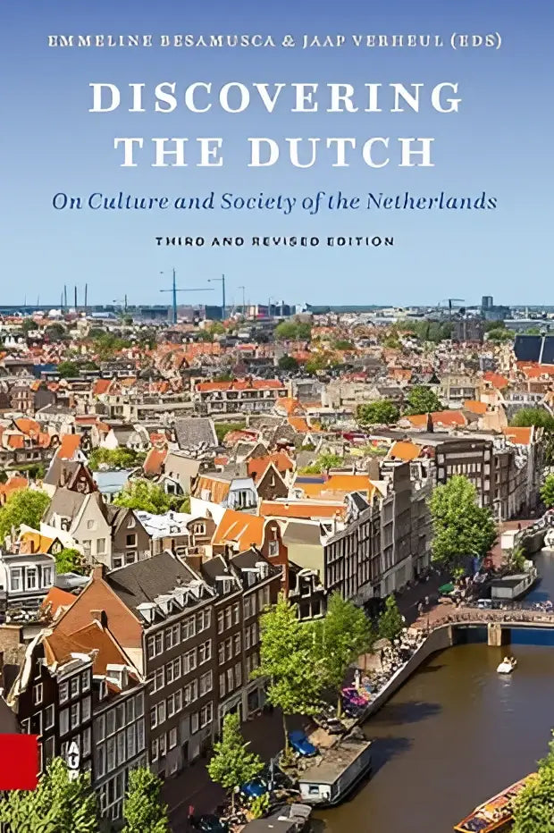 De boekcover van discovering the dutch toont een kleurrijk luchtbeeld van amsterdam met rode daken en grachten